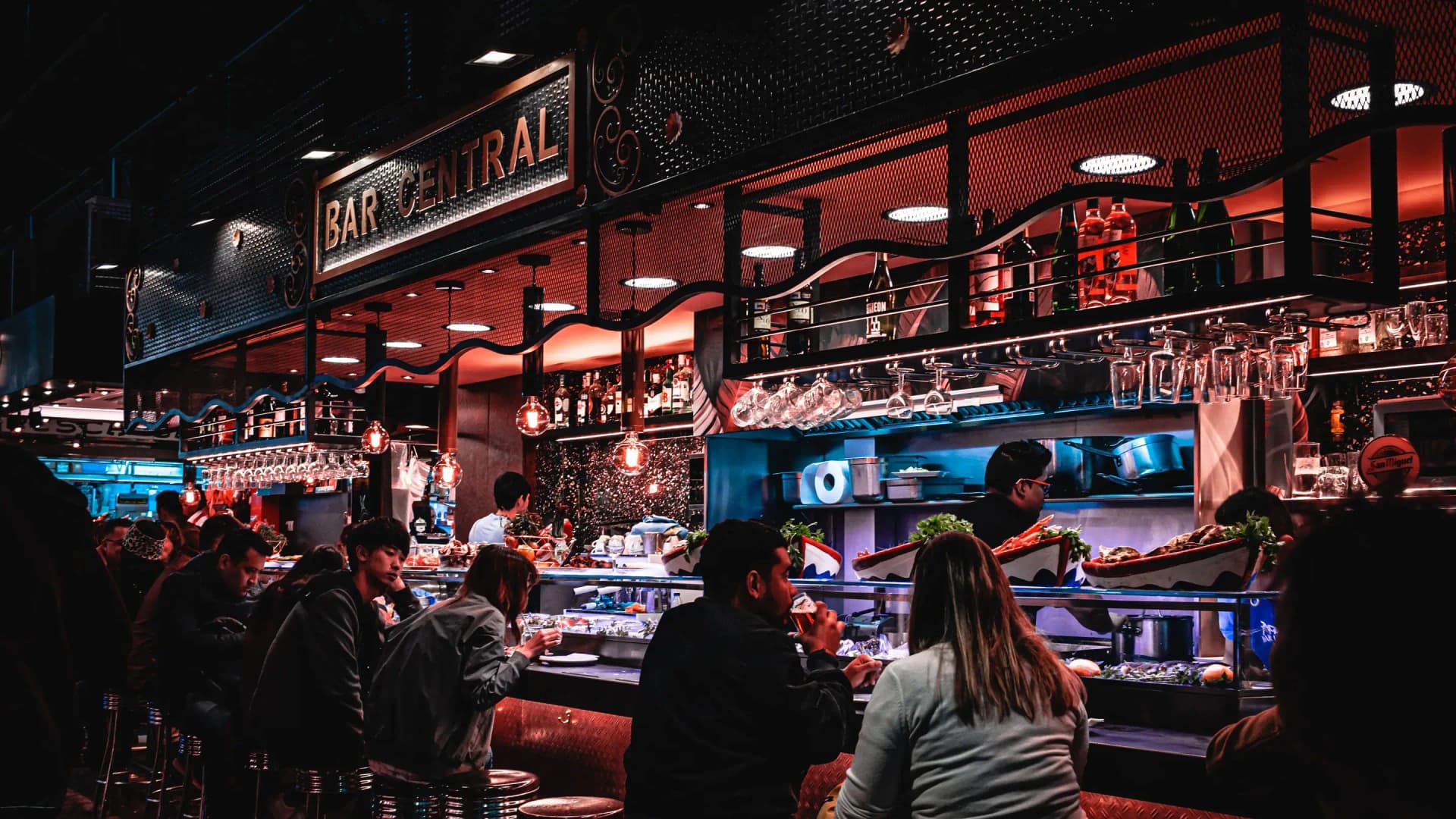 Barra de un bar llena de clientes cenando
